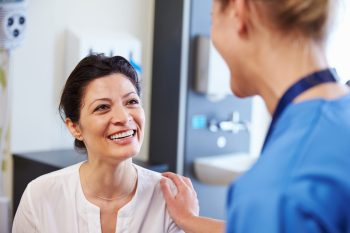 Female Patient Being Reassured By Doctor In Hospital Room Female Patient Being Reassured By Doctor In Hospital Room
